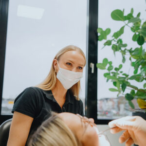 Zahnärztliche Behandlung einer Patientin in der Zahnarztpraxis Rage-Holm in Moers durch eine Mitarbeiterin mit Mundschutz